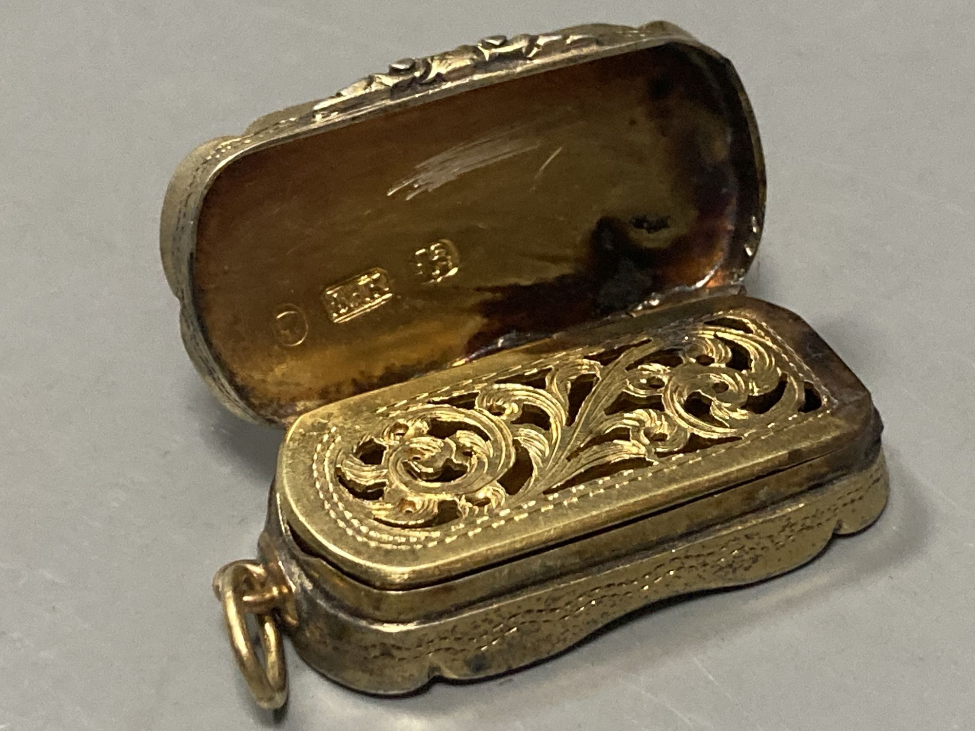 A Victorian silver gilt shaped ovoid vinaigrette, Abraham Kemp, Birmingham, 1853, 33mm.